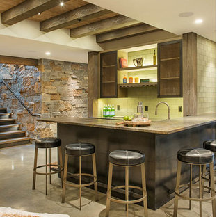 Ejemplo de bar en casa con barra de bar en L, rústico, de tamaño medio, con salpicadero gris, suelo de cemento, suelo gris, salpicadero de azulejos tipo metro y armarios tipo vitrina