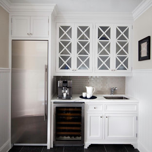 Foto de bar en casa con fregadero lineal, tradicional, con fregadero bajoencimera, armarios con rebordes decorativos, puertas de armario blancas, encimera de mármol, salpicadero beige y salpicadero de azulejos tipo metro