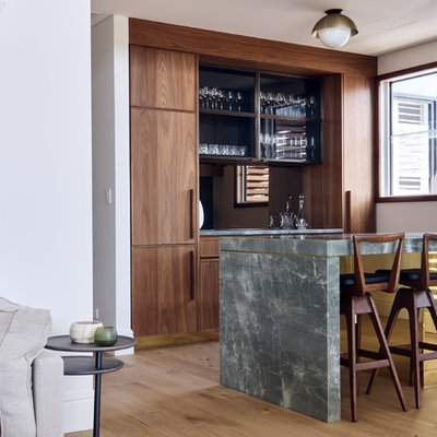 Seated home bar - contemporary galley medium tone wood floor and brown floor seated home bar idea in Sydney with flat-panel cabinets, dark wood cabinets and gray countertops