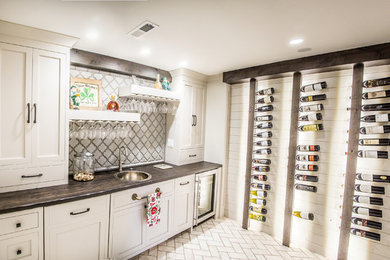 Example of a large home bar design in Other with wood countertops, gray backsplash and brown countertops