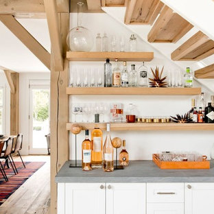 Diseño de bar en casa lineal, de estilo de casa de campo, con puertas de armario blancas, encimera de piedra caliza, salpicadero blanco y armarios estilo shaker
