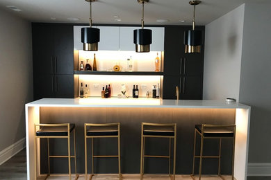 Seated home bar - mid-sized 1960s u-shaped vinyl floor and gray floor seated home bar idea in Chicago with an undermount sink, flat-panel cabinets, black cabinets, quartz countertops, white backsplash, stone slab backsplash and white countertops