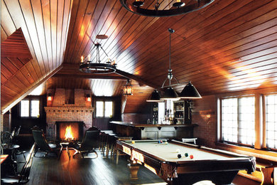 Modelo de bar en casa con barra de bar en L tradicional grande con armarios con paneles lisos, puertas de armario de madera en tonos medios y suelo de madera oscura
