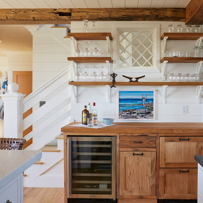 Beach style single-wall home bar photo in Portland Maine with no sink, shaker cabinets, medium tone wood cabinets, wood countertops and white backsplash
