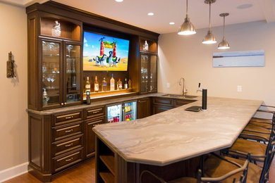 Large transitional u-shaped medium tone wood floor wet bar photo in New York with an undermount sink, glass-front cabinets and dark wood cabinets