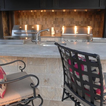 Outdoor Kitchen with Clean Concrete Countertops with Charcoal and Gas Grills
