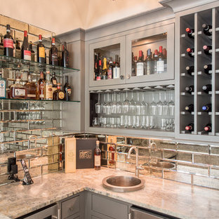 Foto de bar en casa con fregadero en U, costero, de tamaño medio, con fregadero encastrado, puertas de armario grises, encimera de granito, salpicadero con efecto espejo, encimeras grises y armarios tipo vitrina