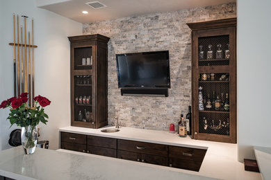 Inspiration for a small modern u-shaped wet bar remodel in Minneapolis with dark wood cabinets, laminate countertops, beige backsplash, stone tile backsplash and recessed-panel cabinets