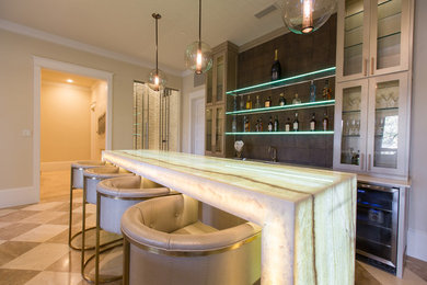 Seated home bar - large contemporary single-wall seated home bar idea in Dallas with an undermount sink, glass-front cabinets, beige cabinets, onyx countertops, brown backsplash and white countertops