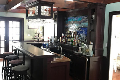 This is an example of a rustic home bar in New York with medium hardwood flooring and brown floors.