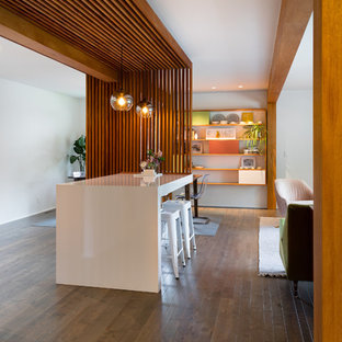 Idee per un bancone bar minimalista di medie dimensioni con nessun lavello, ante lisce, ante in legno scuro, top in laminato, paraspruzzi bianco, parquet scuro e pavimento marrone