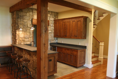 Example of a mid-sized transitional u-shaped travertine floor and beige floor home bar design in Other with flat-panel cabinets, medium tone wood cabinets, an undermount sink, marble countertops and gray backsplash