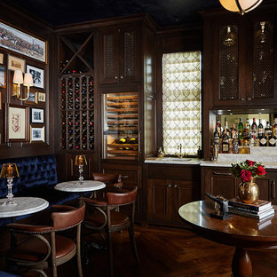 Idée de décoration pour un très grand bar de salon linéaire tradition avec des tabourets, un placard avec porte à panneau encastré, des portes de placard en bois sombre, un sol en bois brun, un sol marron, un plan de travail multicolore, un plan de travail en marbre et un évier encastré.
