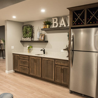 Example of a mid-sized mountain style single-wall light wood floor and brown floor wet bar design in Other with an undermount sink, shaker cabinets, medium tone wood cabinets, quartz countertops, white backsplash and white countertops