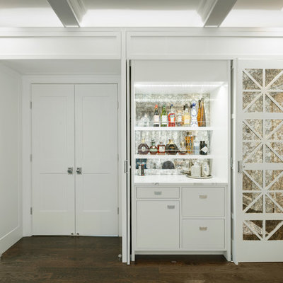 Inspiration for a small coastal single-wall dark wood floor and brown floor home bar remodel in New York with no sink, flat-panel cabinets, white cabinets, white countertops, quartzite countertops and mirror backsplash