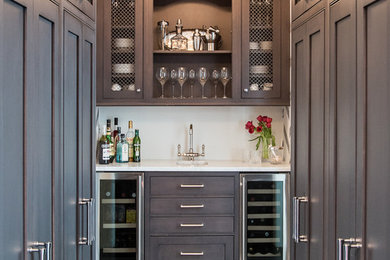 Wet bar - large transitional single-wall wet bar idea in New York with brown cabinets, white backsplash and white countertops