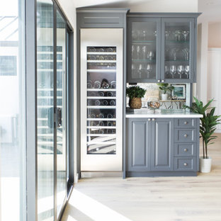 Ispirazione per un piccolo angolo bar con lavandino classico con ante in stile shaker, ante grigie, paraspruzzi con lastra di vetro, parquet chiaro, pavimento beige, top bianco e top in marmo
