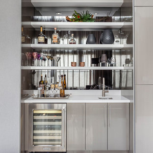 Esempio di un angolo bar con lavandino contemporaneo con lavello sottopiano, ante lisce, ante grigie, paraspruzzi a specchio e pavimento bianco