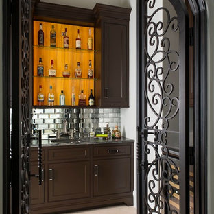 Esempio di un angolo bar con lavandino chic di medie dimensioni con lavello sottopiano, ante in legno bruno, ante con riquadro incassato, top in granito, paraspruzzi grigio, pavimento beige, pavimento in marmo e paraspruzzi a specchio