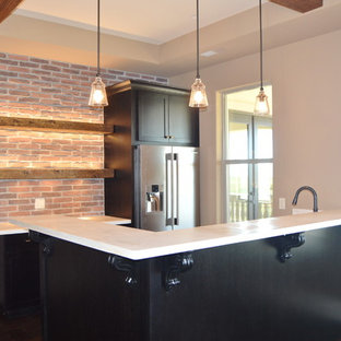 Idées déco pour un bar de salon avec évier classique en L de taille moyenne avec un placard à porte shaker, des portes de placard noires, un plan de travail en surface solide et un sol en bois foncé.
