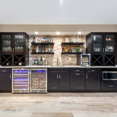 Seated home bar - large contemporary single-wall porcelain tile and beige floor seated home bar idea in DC Metro with an undermount sink, shaker cabinets, dark wood cabinets, granite countertops, brown backsplash, travertine backsplash and gray countertops
