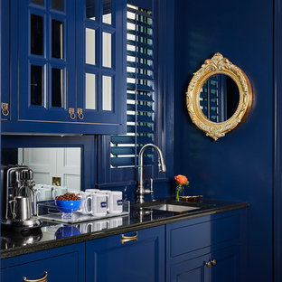 Inspiration for a timeless single-wall wet bar remodel in Minneapolis with an undermount sink, recessed-panel cabinets, blue cabinets, mirror backsplash and black countertops