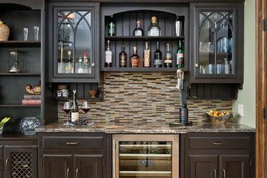Design ideas for a medium sized classic single-wall home bar in New York with glass-front cabinets, dark wood cabinets, granite worktops, multi-coloured splashback, mosaic tiled splashback, porcelain flooring and beige floors.