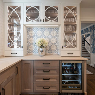 Idee per un angolo bar chic di medie dimensioni con ante in stile shaker, ante in legno chiaro, paraspruzzi multicolore, pavimento in legno massello medio, pavimento marrone e top beige