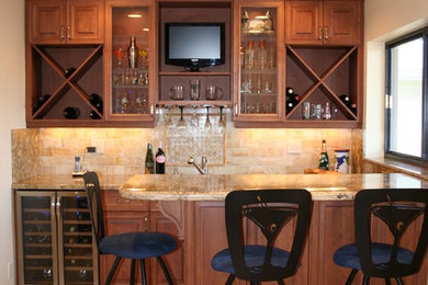 Mid-sized arts and crafts single-wall travertine floor and brown floor wet bar photo in Miami with raised-panel cabinets, medium tone wood cabinets, granite countertops, beige backsplash and stone tile backsplash