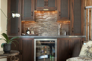 Example of a mid-sized arts and crafts single-wall dark wood floor wet bar design in Detroit with an undermount sink, shaker cabinets, dark wood cabinets, stainless steel countertops, beige backsplash and matchstick tile backsplash