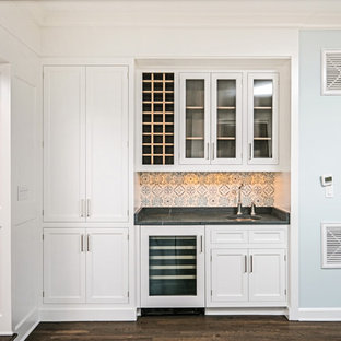 Idee per un piccolo angolo bar con lavandino chic con lavello sottopiano, ante a filo, ante bianche, top in saponaria, paraspruzzi multicolore, paraspruzzi con piastrelle in terracotta, parquet scuro e top nero