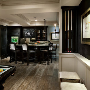 Cette photo montre un très grand bar de salon moderne en U avec un placard avec porte à panneau surélevé, des portes de placard en bois sombre, un plan de travail en onyx, une crédence marron, une crédence en bois, un sol en bois clair, un sol marron et un plan de travail beige.