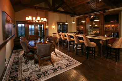 Example of a classic medium tone wood floor home bar design in Nashville with glass-front cabinets, dark wood cabinets, granite countertops and mirror backsplash