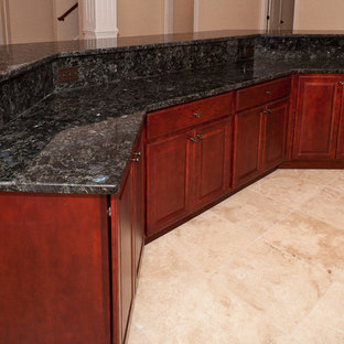 Aménagement d'un très grand bar de salon classique avec des tabourets, un évier encastré, un placard avec porte à panneau surélevé, des portes de placard en bois sombre, un plan de travail en granite et un sol en marbre.