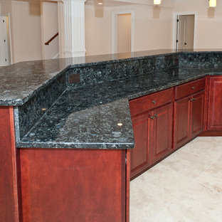 Idée de décoration pour un très grand bar de salon tradition avec des tabourets, un évier encastré, un placard avec porte à panneau surélevé, des portes de placard en bois sombre, un plan de travail en granite et un sol en marbre.