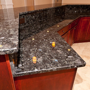 Cette image montre un très grand bar de salon traditionnel avec des tabourets, un évier encastré, un placard avec porte à panneau surélevé, des portes de placard en bois sombre, un plan de travail en granite et un sol en marbre.