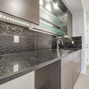 Cette image montre un bar de salon avec évier linéaire style shabby chic de taille moyenne avec un évier posé, un placard à porte plane, des portes de placard en bois brun, un plan de travail en quartz, une crédence noire, une crédence en carreau de porcelaine, un sol en vinyl et un sol gris.