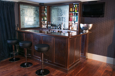 This is an example of a small classic single-wall home bar in Sussex with beaded cabinets, dark wood cabinets and wood worktops.