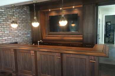 Ejemplo de bar en casa con fregadero clásico renovado con armarios con paneles empotrados y puertas de armario de madera en tonos medios