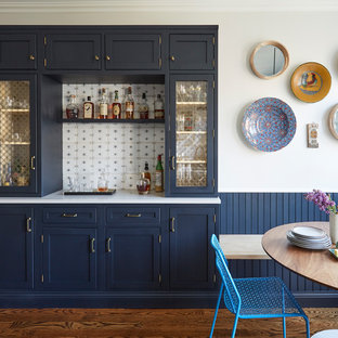 Modelo de bar en casa lineal, campestre, con armarios estilo shaker, puertas de armario azules, salpicadero multicolor, suelo de madera oscura y suelo marrón