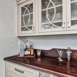 Immagine di un angolo bar con lavandino tradizionale di medie dimensioni con ante a filo, ante beige, top in legno, pavimento in legno verniciato, pavimento marrone e top marrone