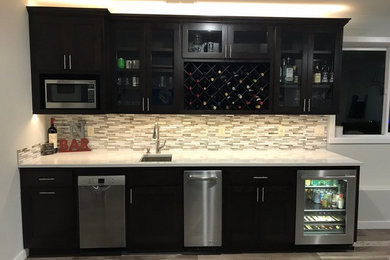 Inspiration for a transitional single-wall wet bar remodel in Seattle with an undermount sink, shaker cabinets, black cabinets, matchstick tile backsplash and white countertops