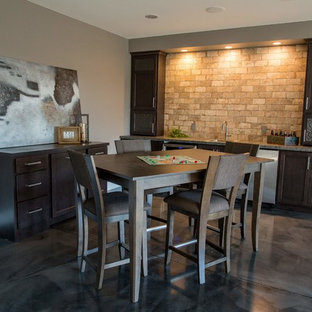 Ispirazione per un bancone bar classico di medie dimensioni con lavello da incasso, ante in stile shaker, ante in legno bruno, top in laminato, paraspruzzi beige, paraspruzzi in mattoni e pavimento in cemento
