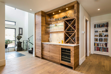 Wet bar - large contemporary single-wall wet bar idea in Vancouver with an undermount sink, flat-panel cabinets, medium tone wood cabinets, quartz countertops, white backsplash, ceramic backsplash and white countertops