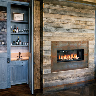 Foto de bar en casa con fregadero lineal, de estilo de casa de campo, con fregadero bajoencimera, puertas de armario azules, suelo de madera oscura y armarios con paneles empotrados