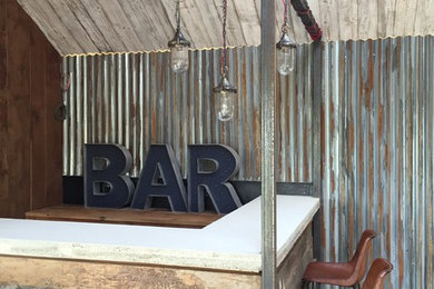 Modelo de bar en casa con barra de bar en L rústico con suelo de madera oscura