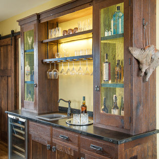Example of a mountain style single-wall medium tone wood floor wet bar design in Other with a drop-in sink and dark wood cabinets