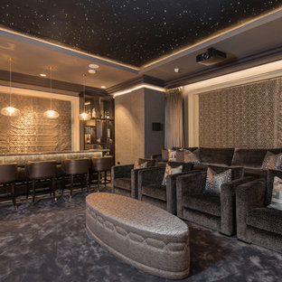 This is an example of an expansive classic enclosed home cinema in Belfast with grey walls, carpet, a projector screen and grey floors.