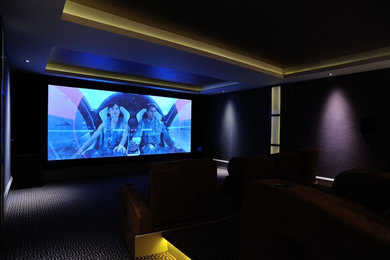 Inspiration for a large contemporary open plan home cinema in London with carpet and a built-in media unit.