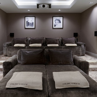 Diseño de cine en casa cerrado, moderno, grande, con moqueta, pantalla de proyección y paredes grises